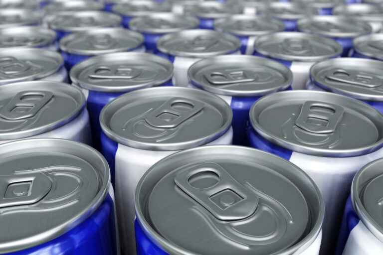 Top view of many cans of energy drinks on a table together.