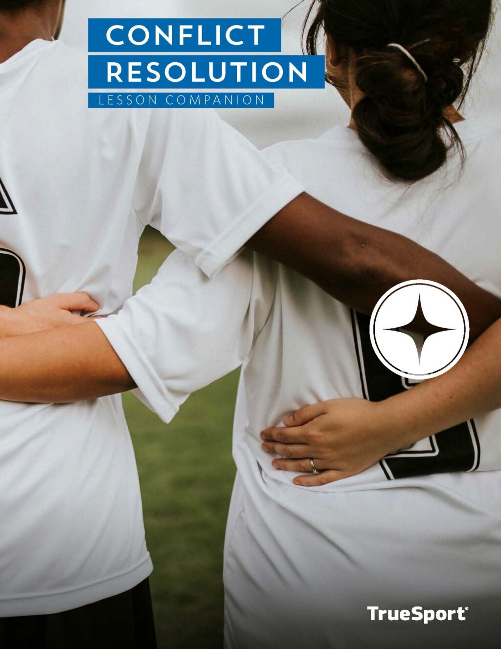 Female athletes standing with back to camera with arms around each other