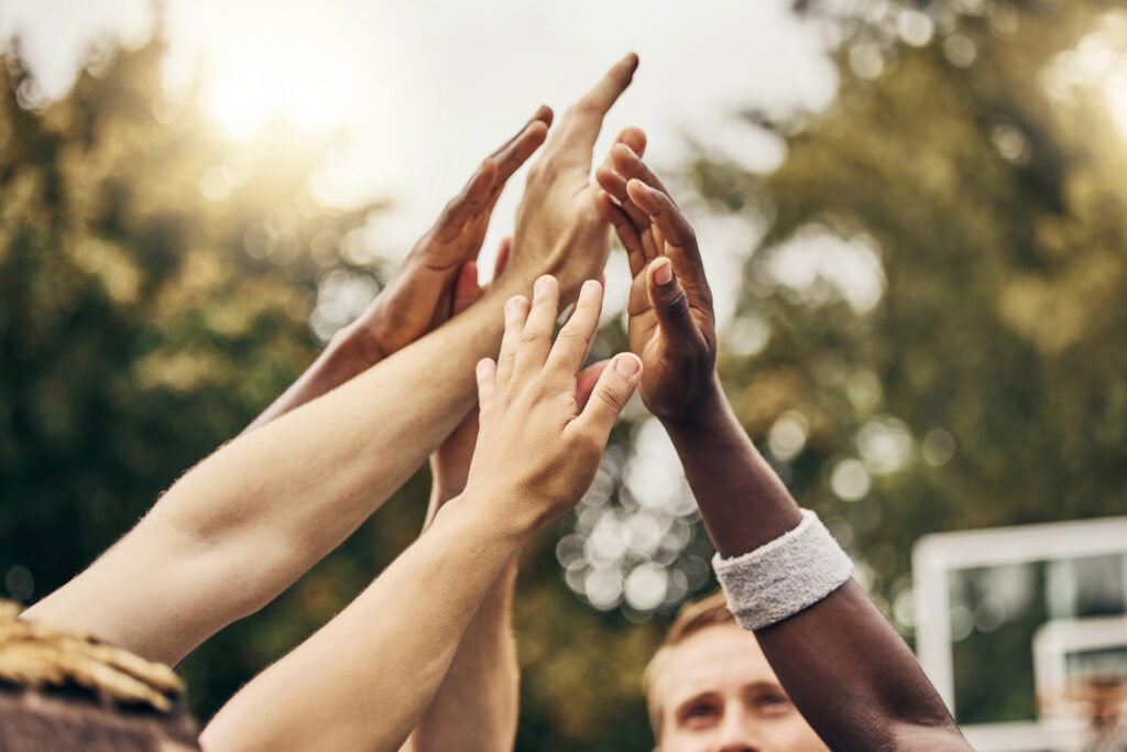 Athletes join hands in a show of teamwork and unity, reflecting Clean Sport values.