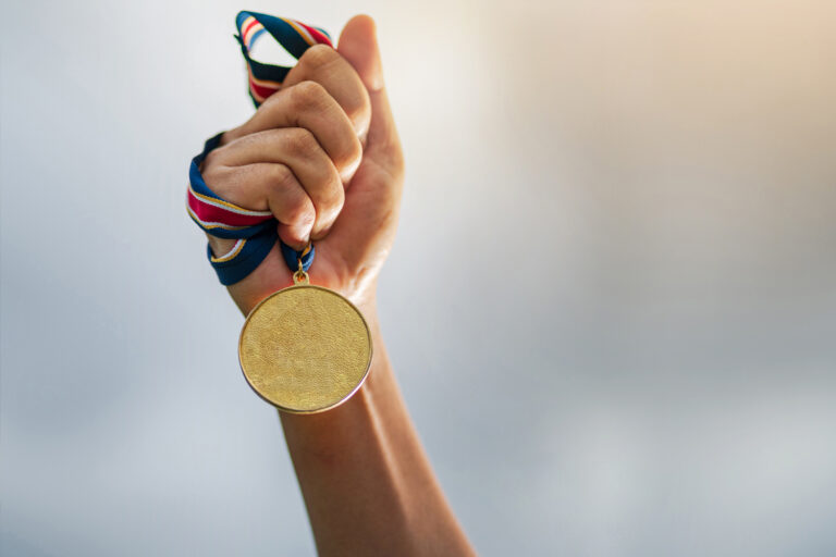 Athlete holding a gold medal symbolizing achievement in clean sport.